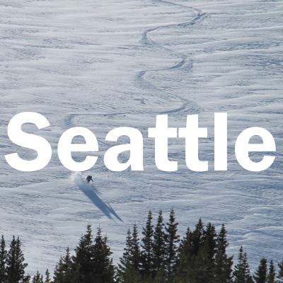 "Seattle" over a photo of a person skiing down a mountain